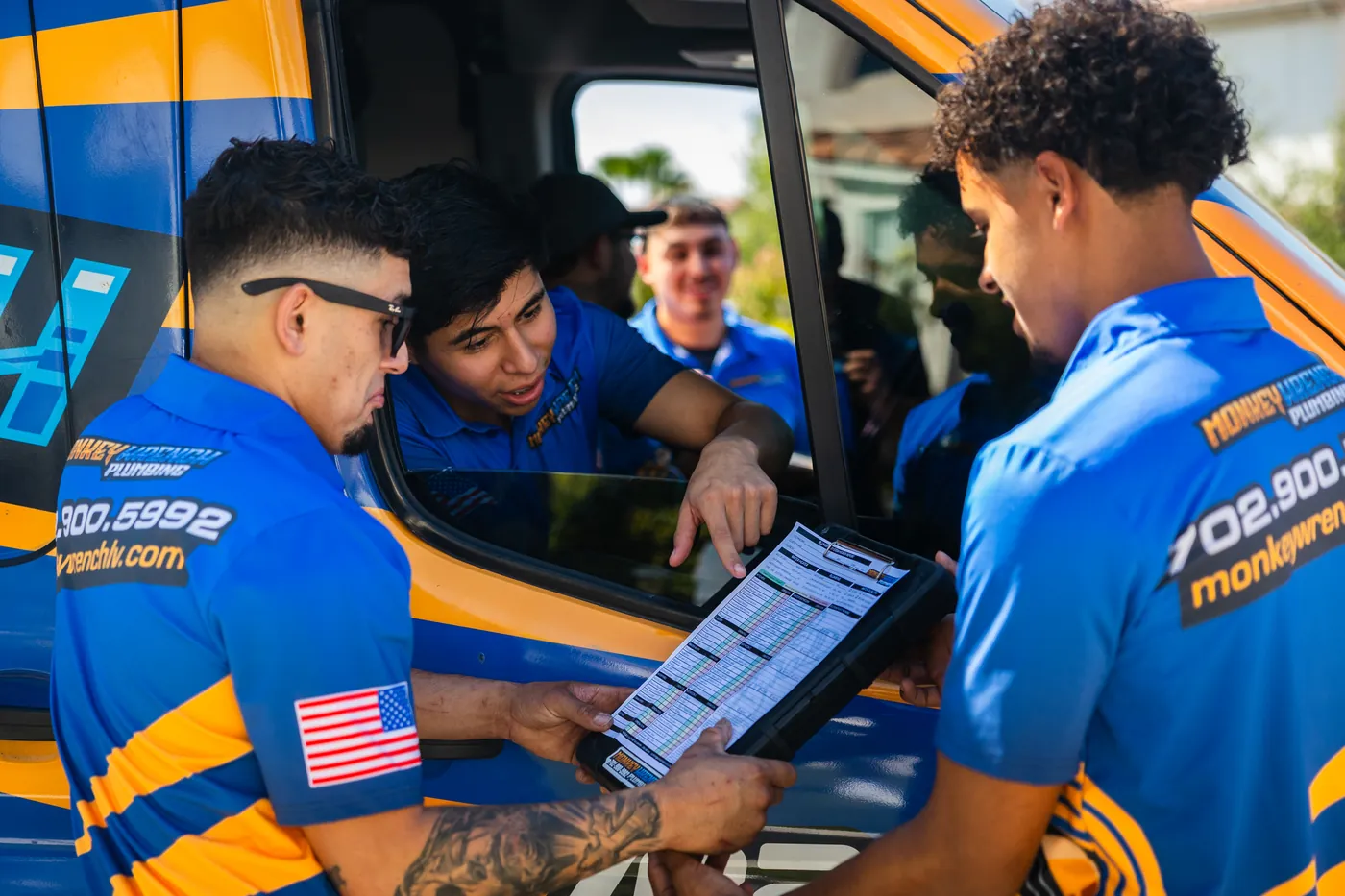 Monkey Wrench technicians reviewing a job checklist before starting work at a Las Vegas home
